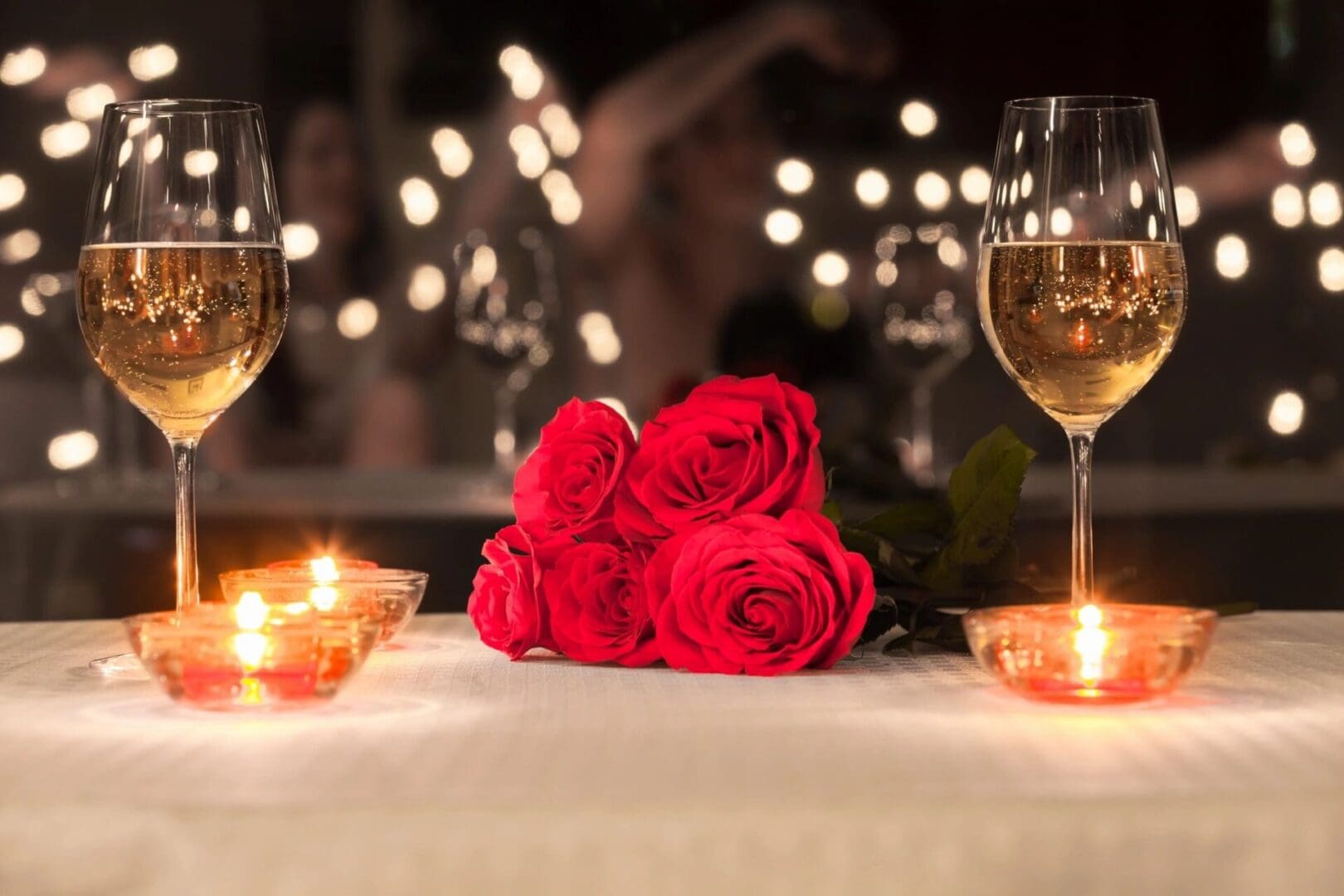 Romantic table setting with roses and candles.